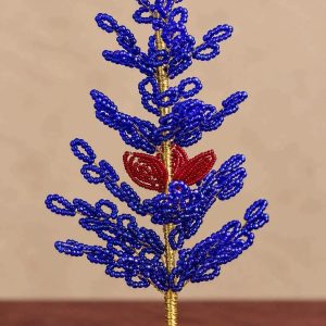 Blue beaded Christmas tree with red floral accent, gold-tone stem and rustic wooden base