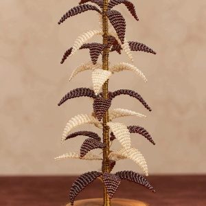 Brown and pearl-white beaded Christmas tree with red berry accents and wooden base