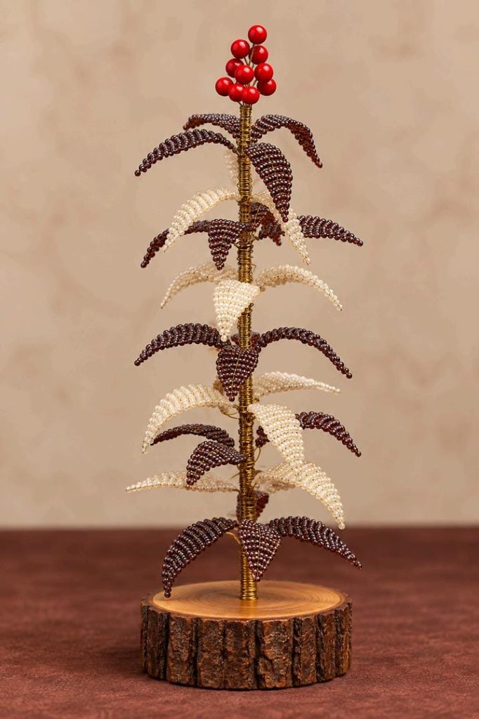 Brown and pearl-white beaded Christmas tree with red berry accents and wooden base