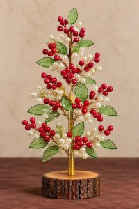 Red berry and pearl beaded Christmas tree with translucent green leaves and rustic wooden base