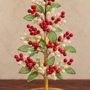 Red berry and pearl beaded Christmas tree with translucent green leaves and rustic wooden base